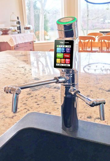 A kitchen faucet with a cell phone attached to it
