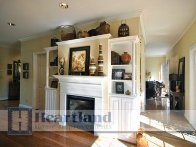 A living room with a fireplace and a heartland logo