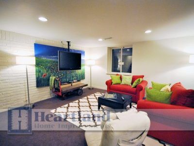 A living room with red couches and a flat screen tv