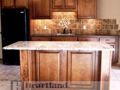 A kitchen with wooden cabinets and a granite counter top