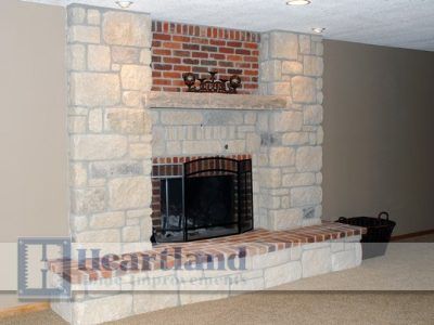 A large stone fireplace with a brick surround