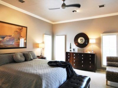 A bedroom with a large bed and a ceiling fan