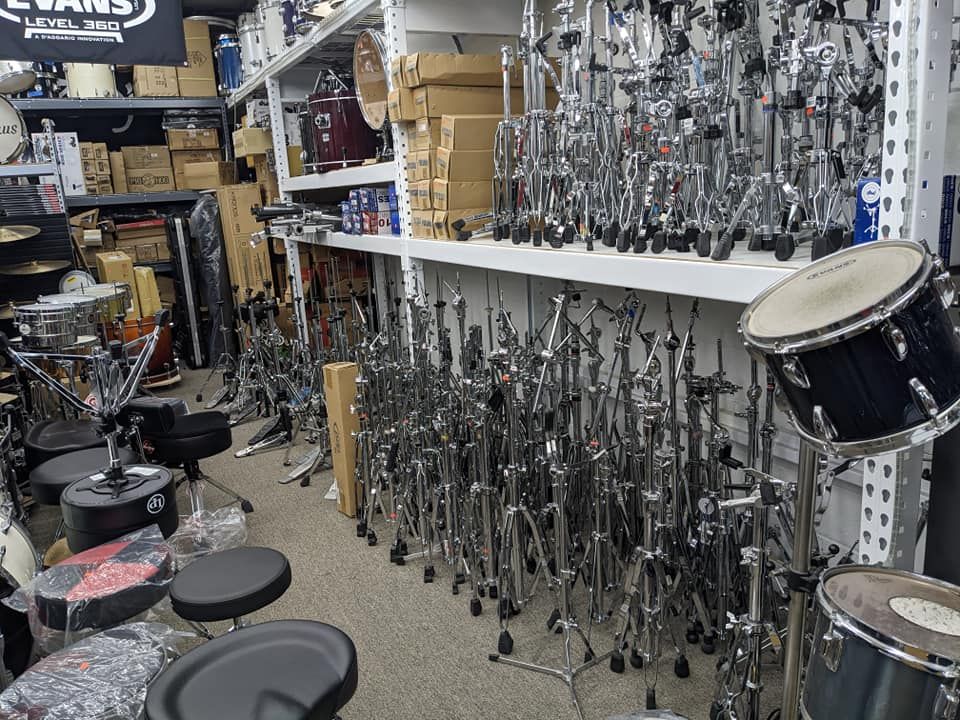 A drum store interior with numerous drum sets, stands, and accessories on display