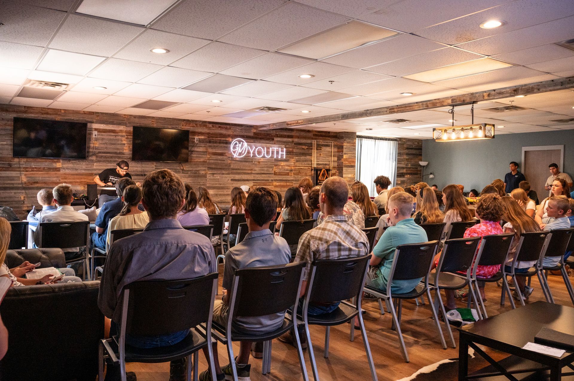 Audience seated, facing a stage with a