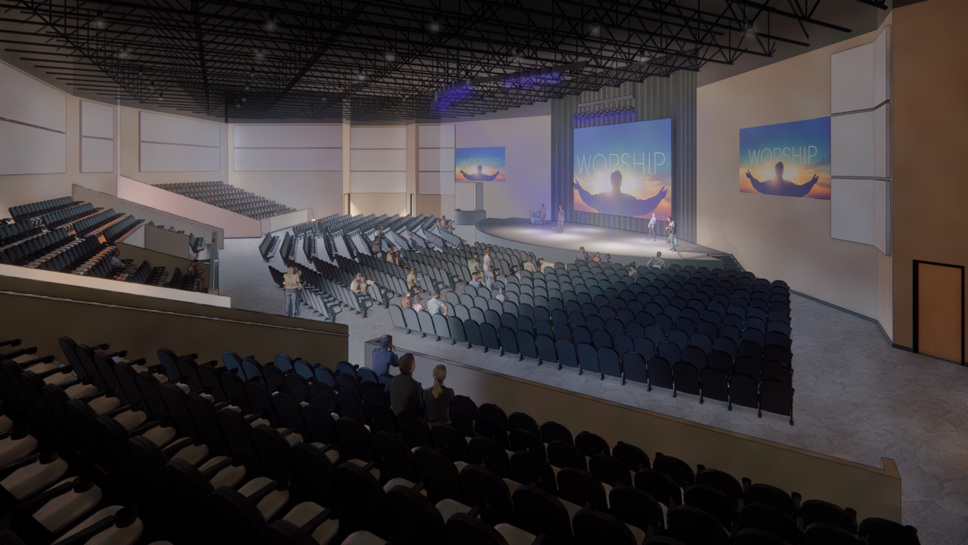 Auditorium interior with tiered seating, stage, and large screens. People seated, stage lit, with curved design.