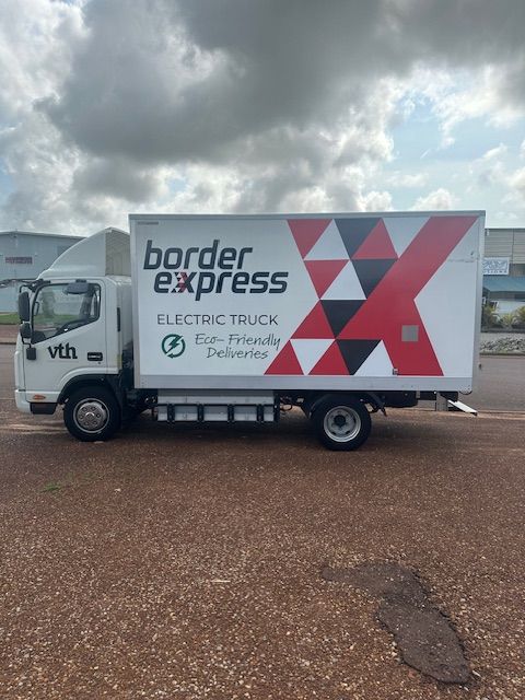 A Green Jurassic Park Car Is Parked In A Garage — Northern Territory Sign Services in Winnellie, NT
