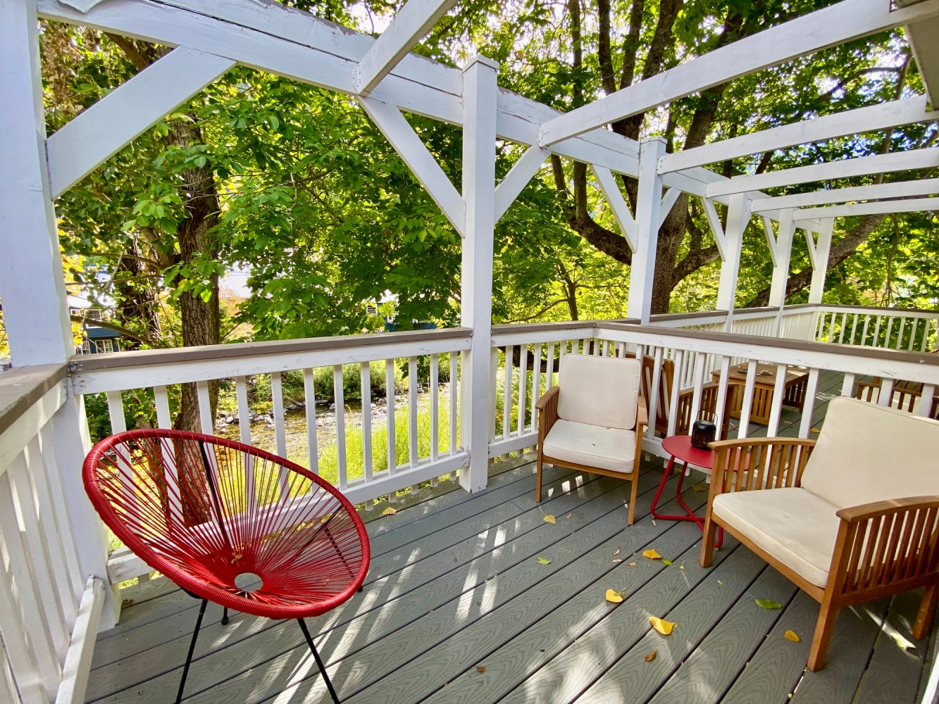 A deck with chairs and a red chair on it