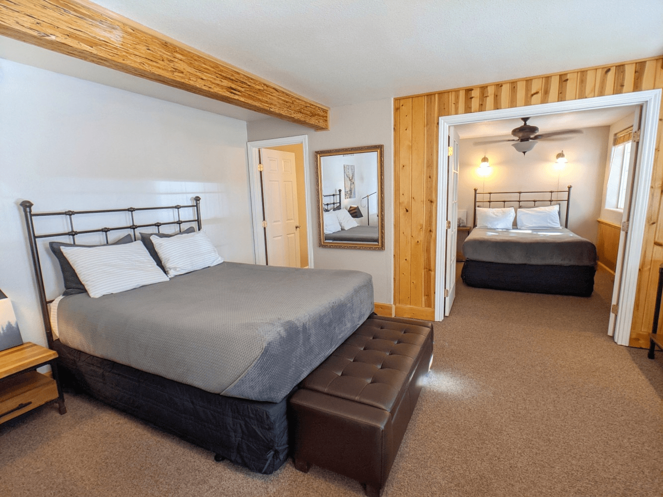 A bedroom with two beds and a ceiling fan