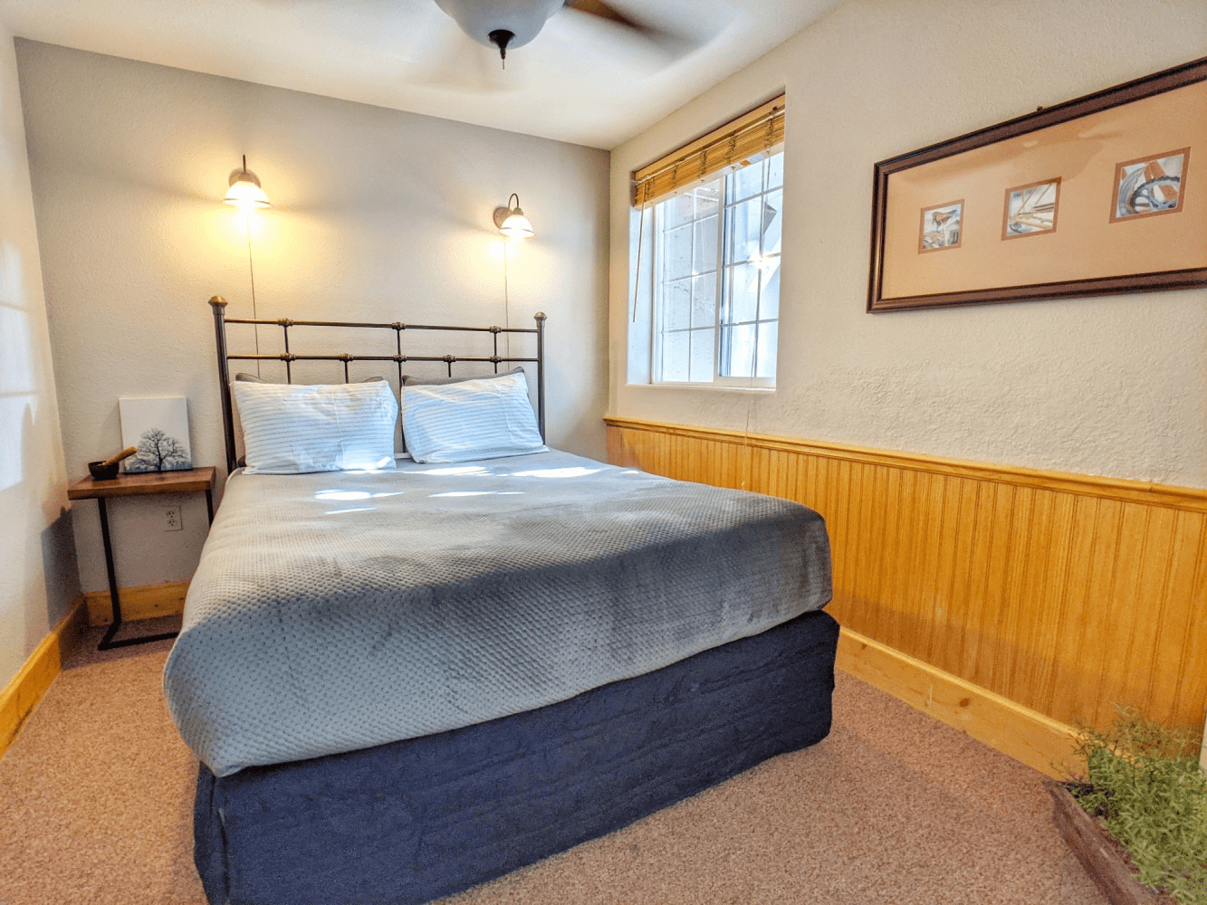 A bedroom with a king size bed and a ceiling fan.