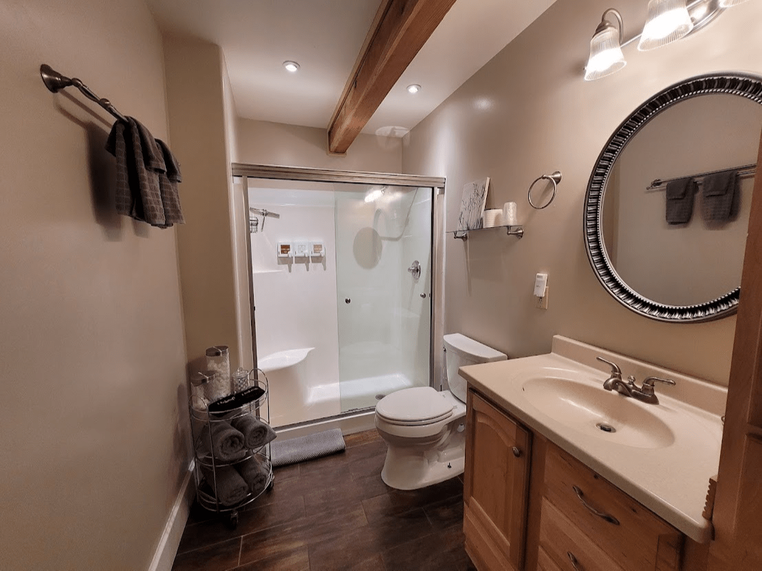 A bathroom with a toilet a sink and a mirror