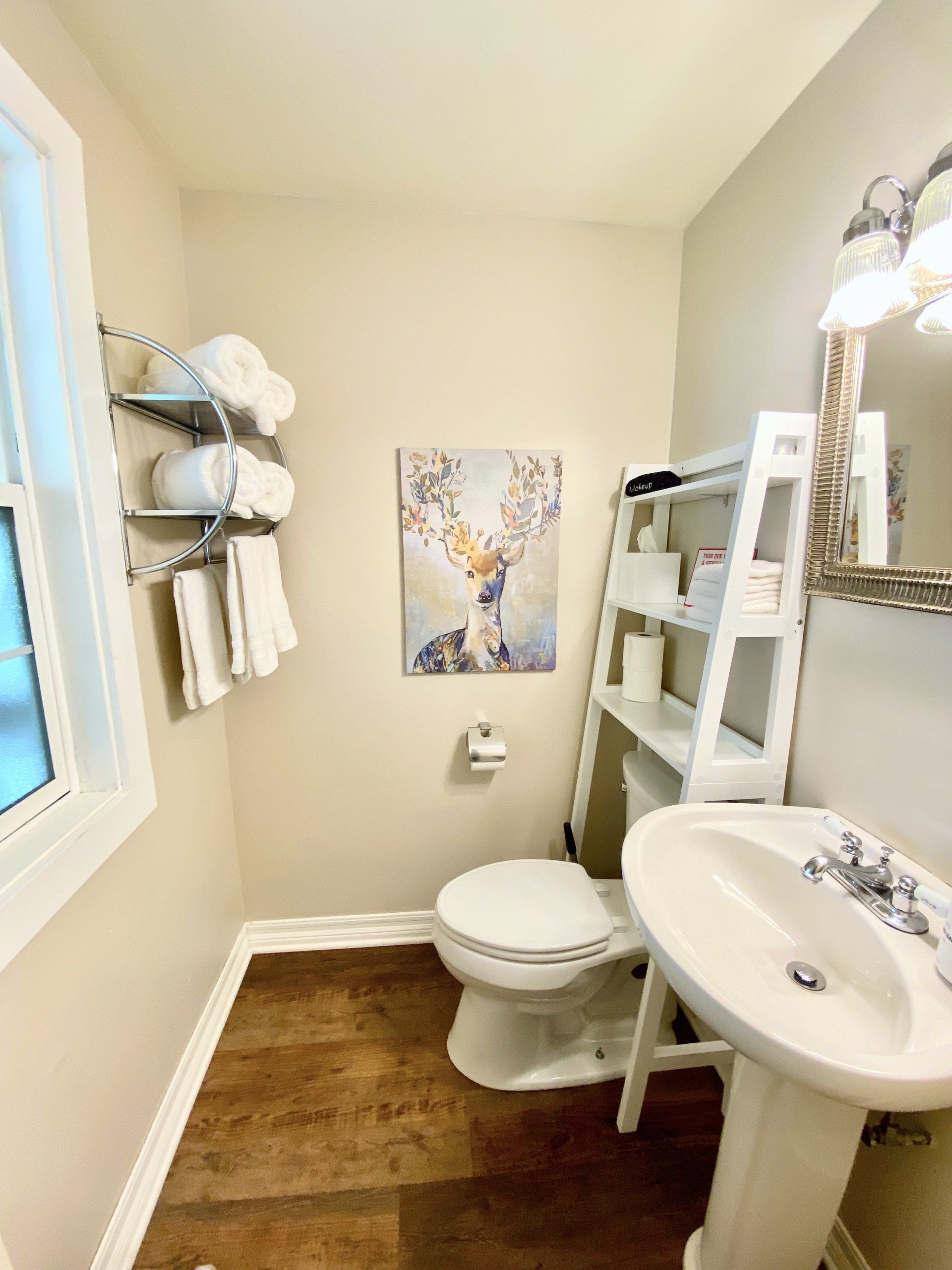 A bathroom with a toilet , sink and mirror.