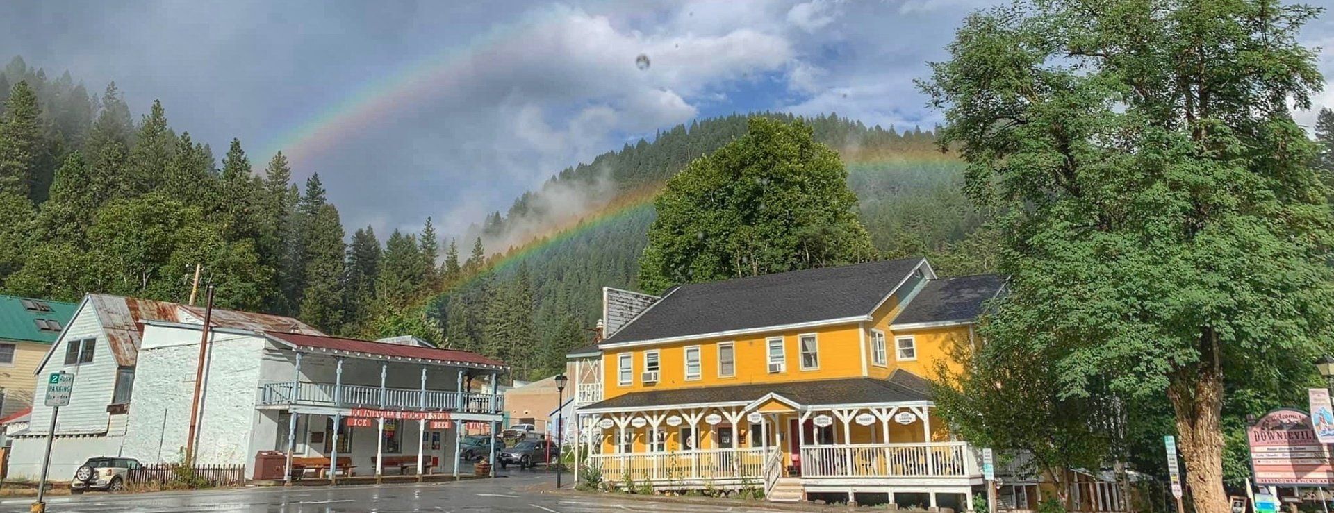 There is a rainbow in the sky over a small town.