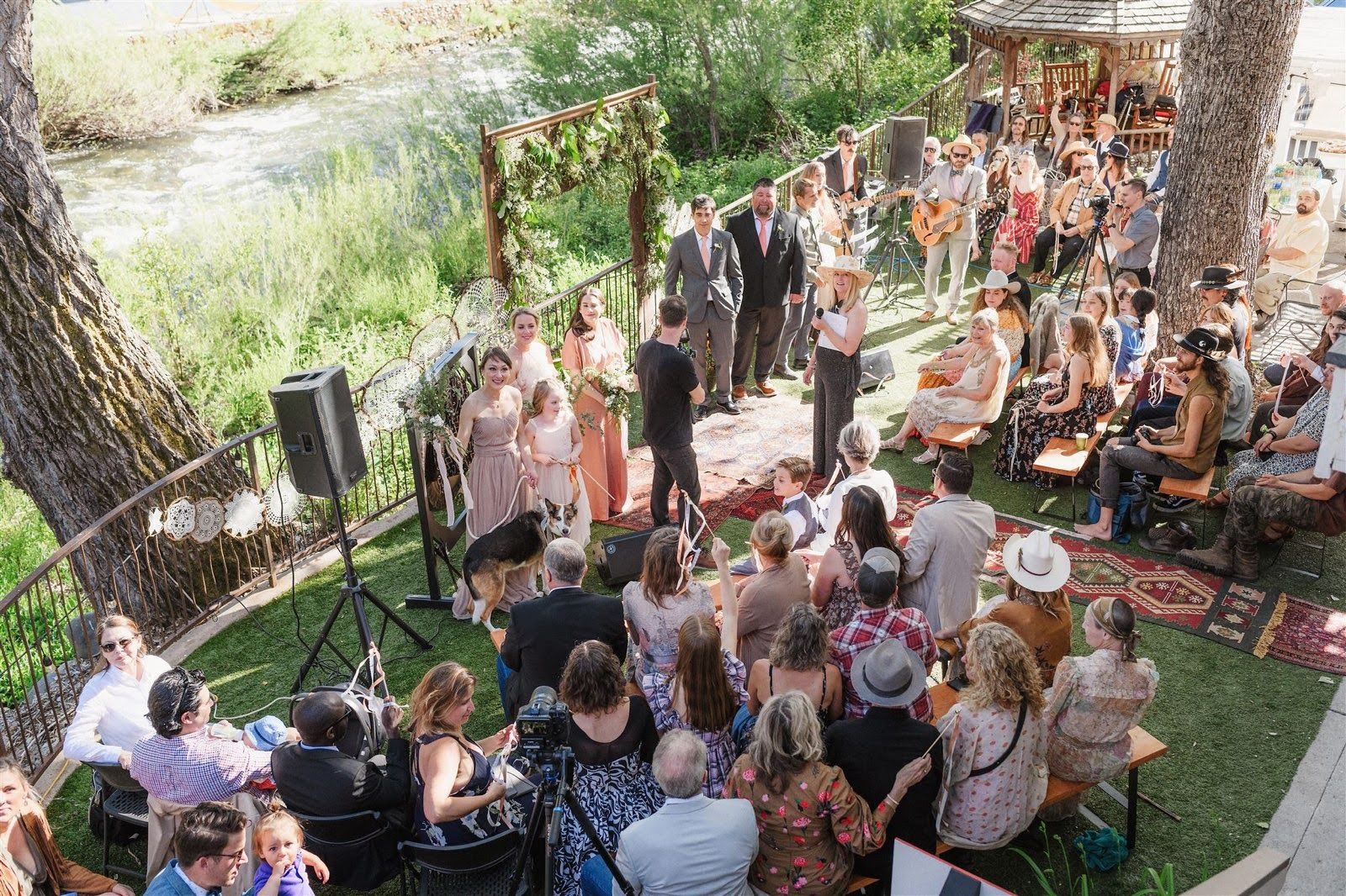 A large group of people are sitting in a circle at a wedding ceremony.