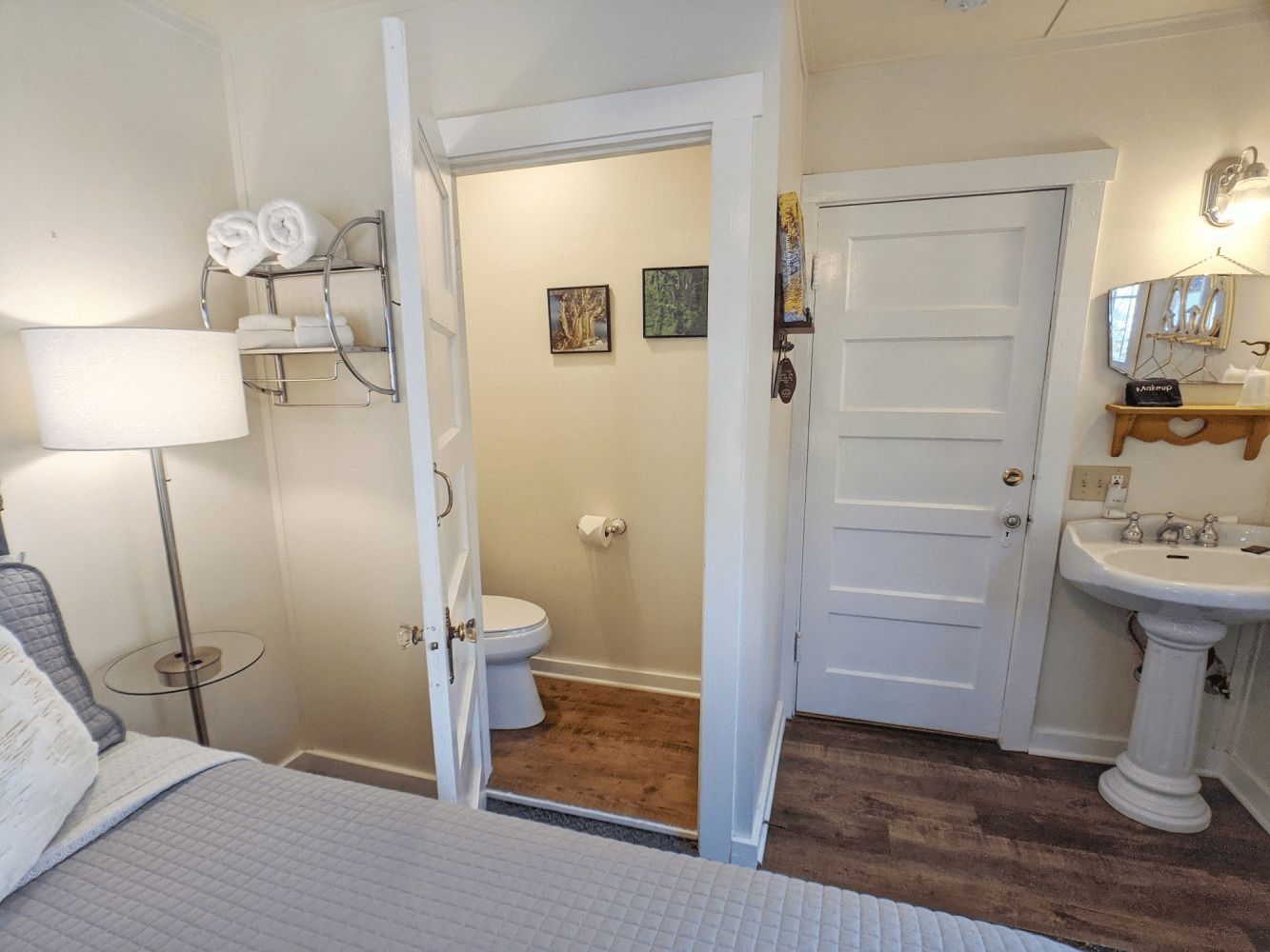 A bedroom with a toilet , sink and mirror.