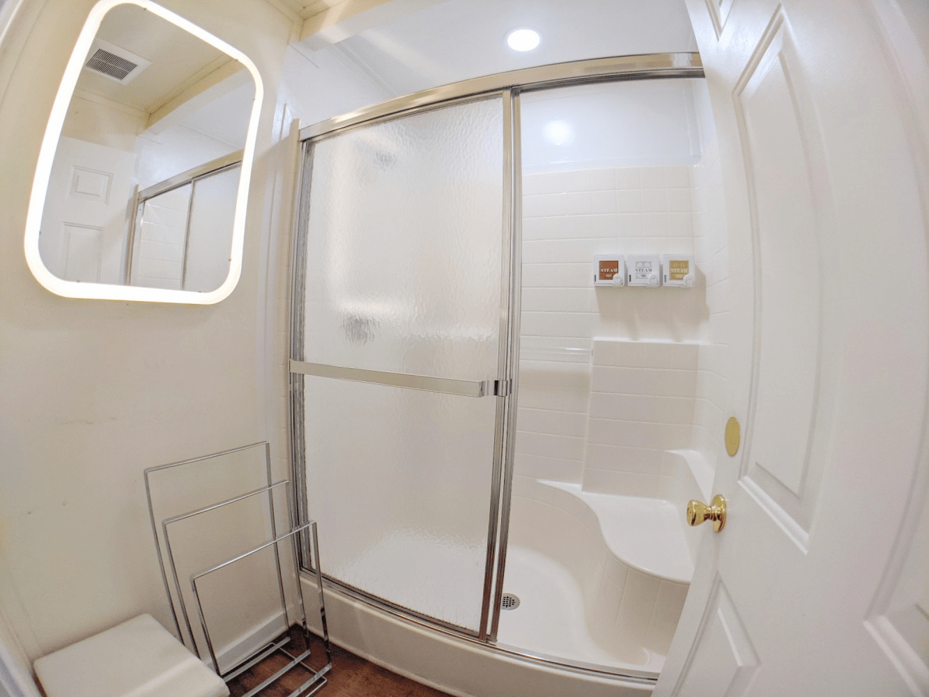 A bathroom with a tub , shower and mirror