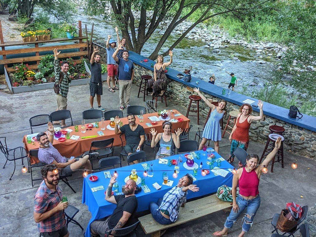 A group of people are standing around a table with their arms in the air.