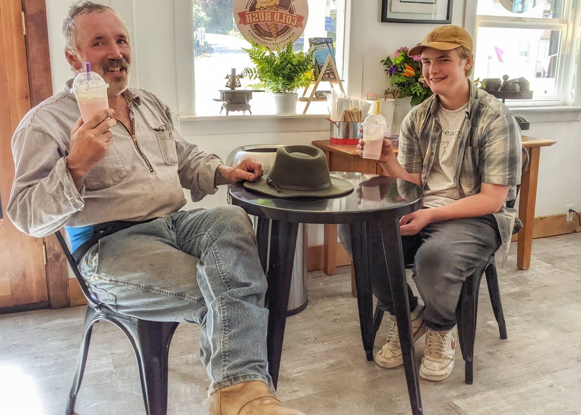 A man and a boy are sitting at a table eating ice cream