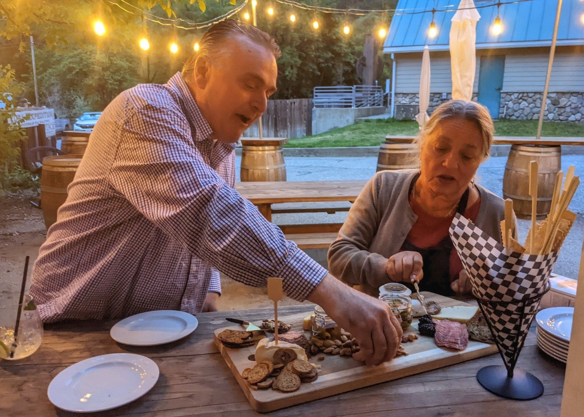 A man and a woman are sitting at a table eating food.