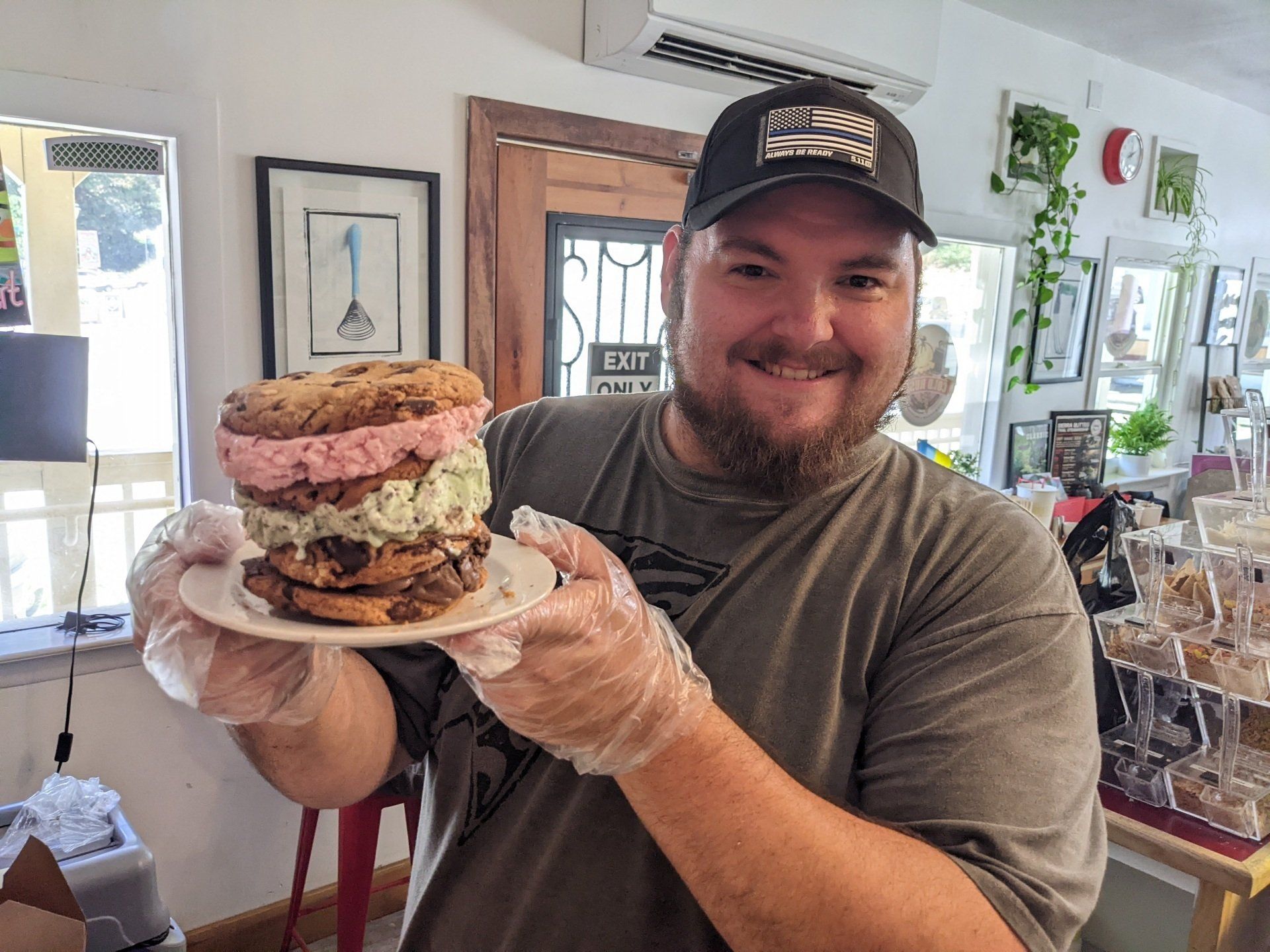 A man is holding a plate with a sandwich on it.