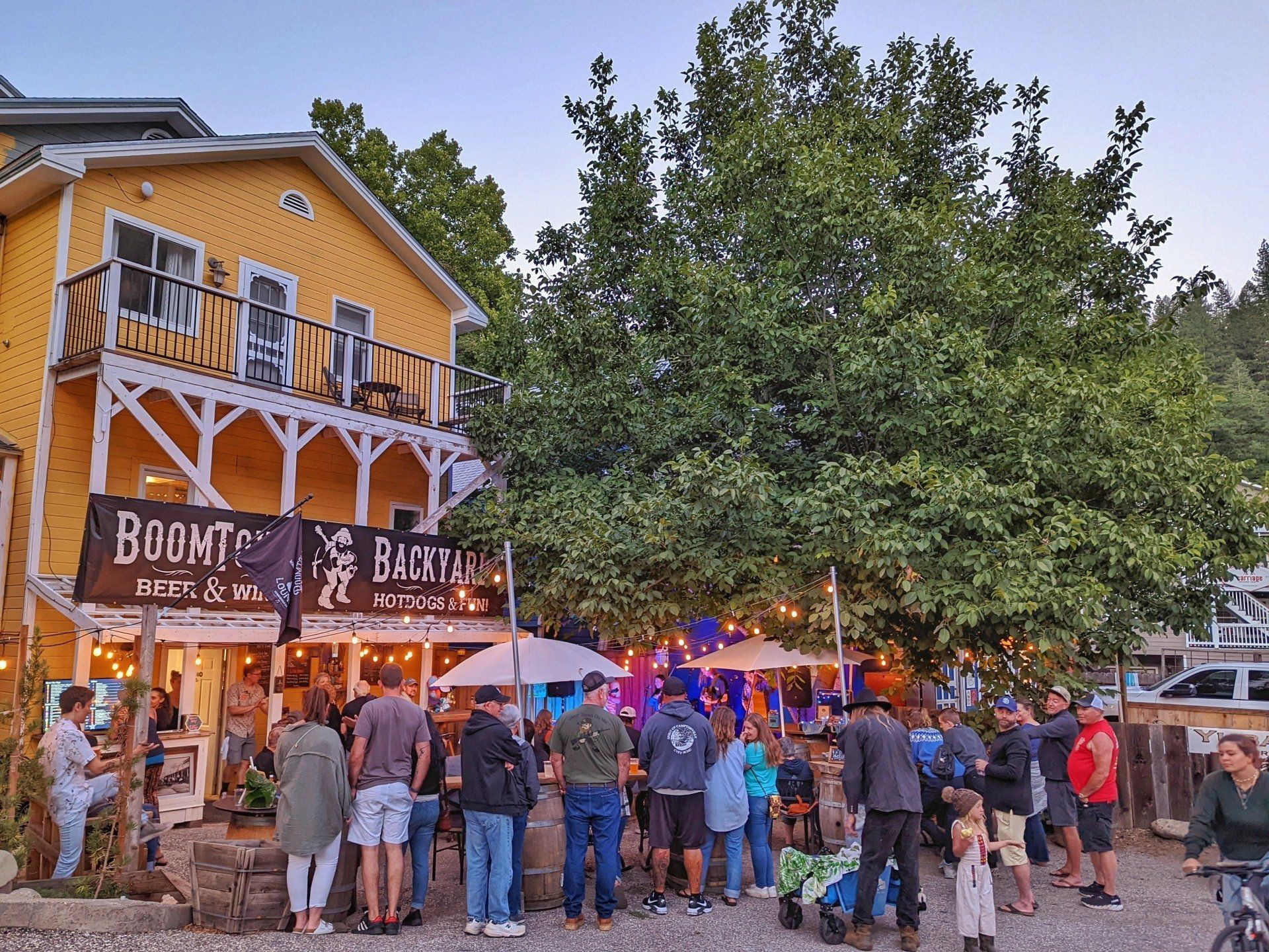 A group of people are standing in front of a yellow building.