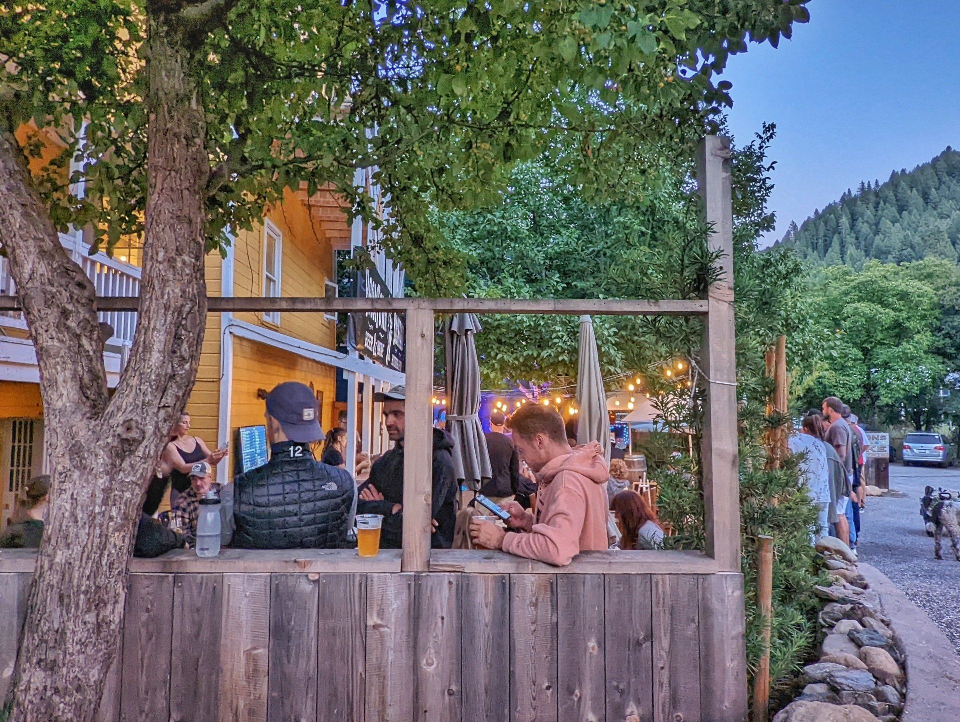 A group of people are sitting at a table outside of a restaurant.