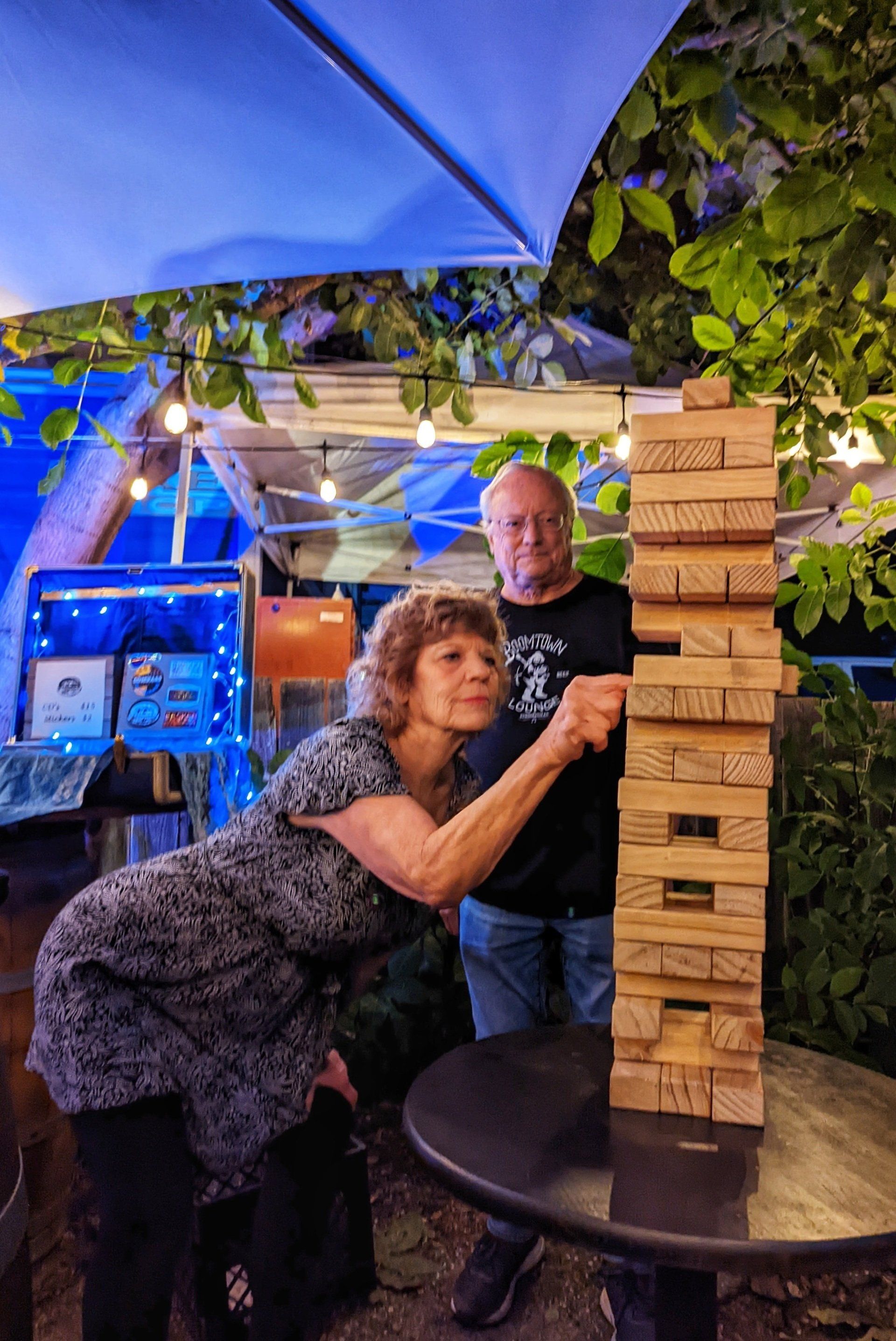 A man and a woman are playing a game of jenga outside.