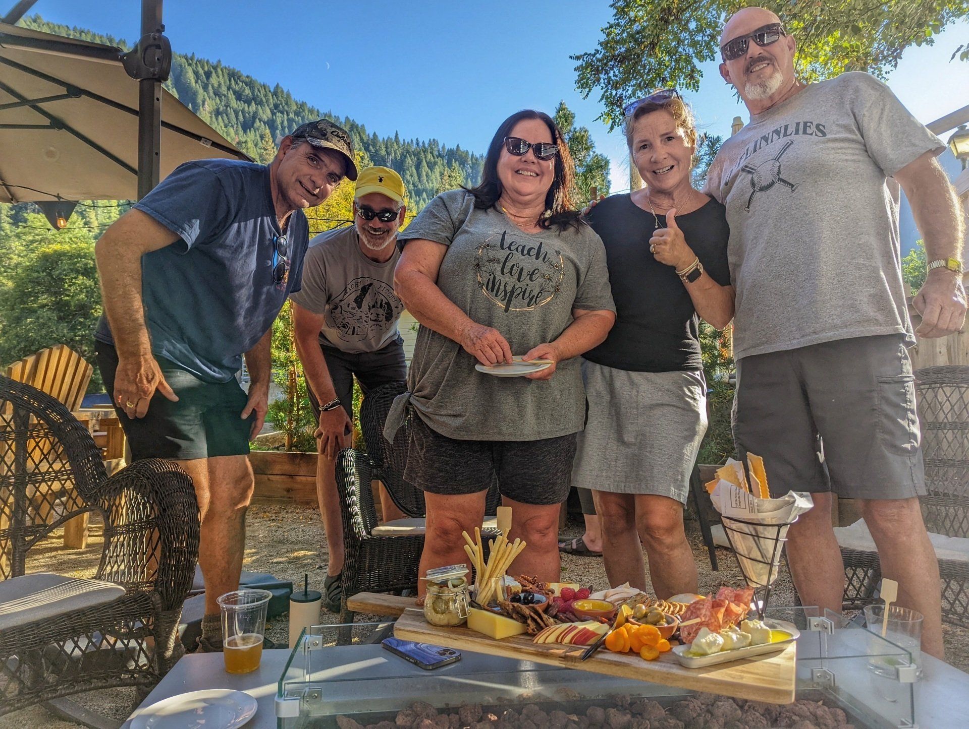 A group of people standing around a table with food on it.