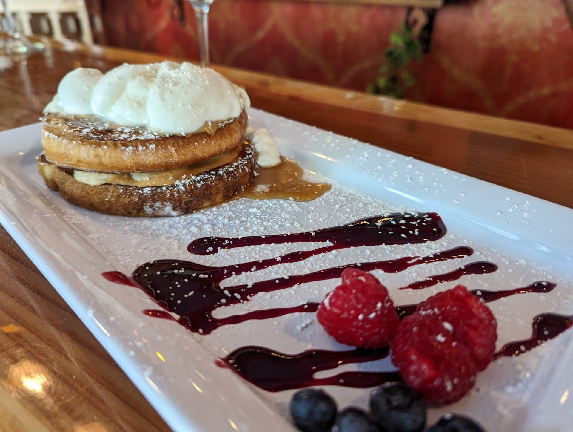 A white plate topped with a dessert with raspberries and blueberries.