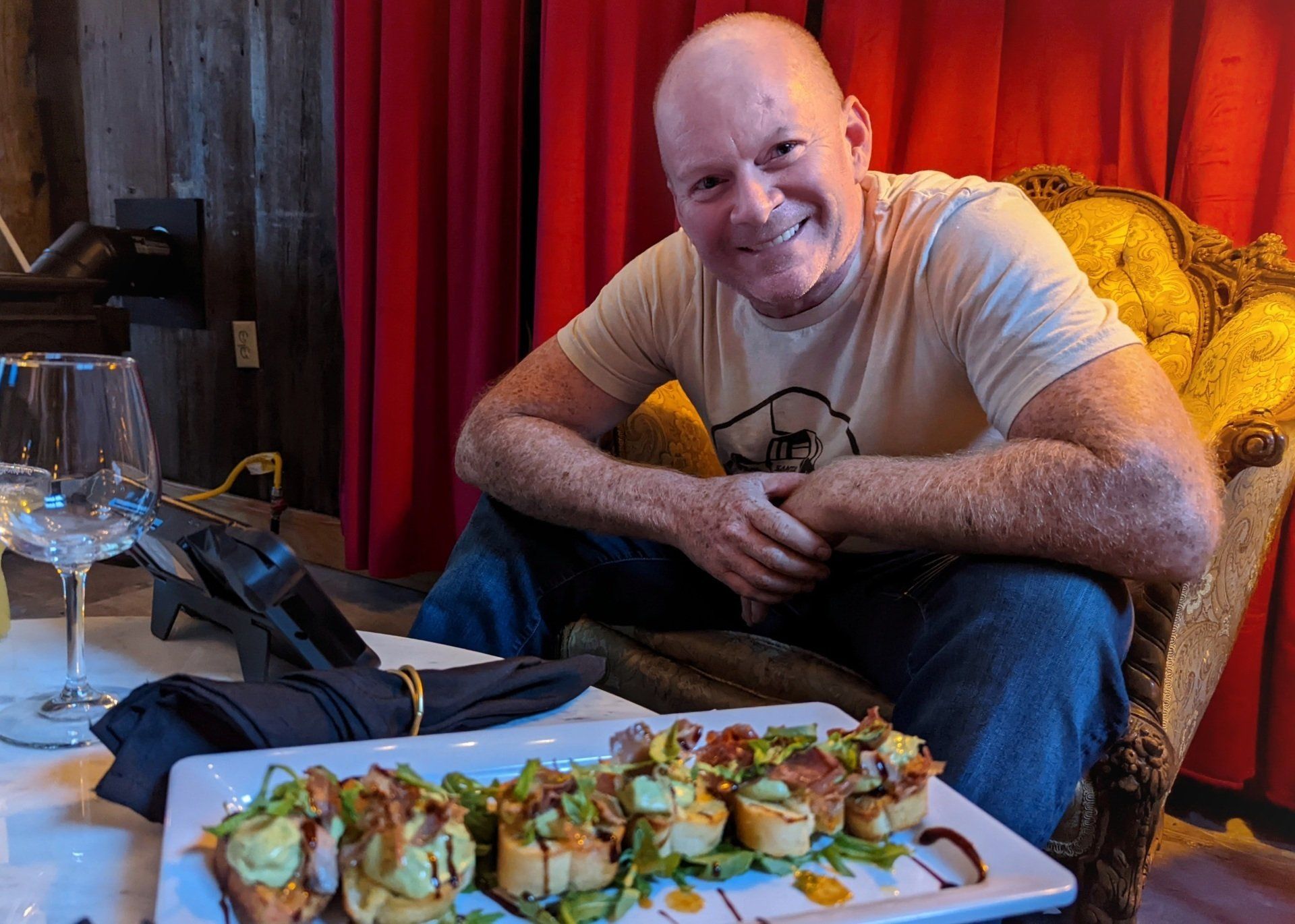 A man is sitting in a chair next to a plate of food.