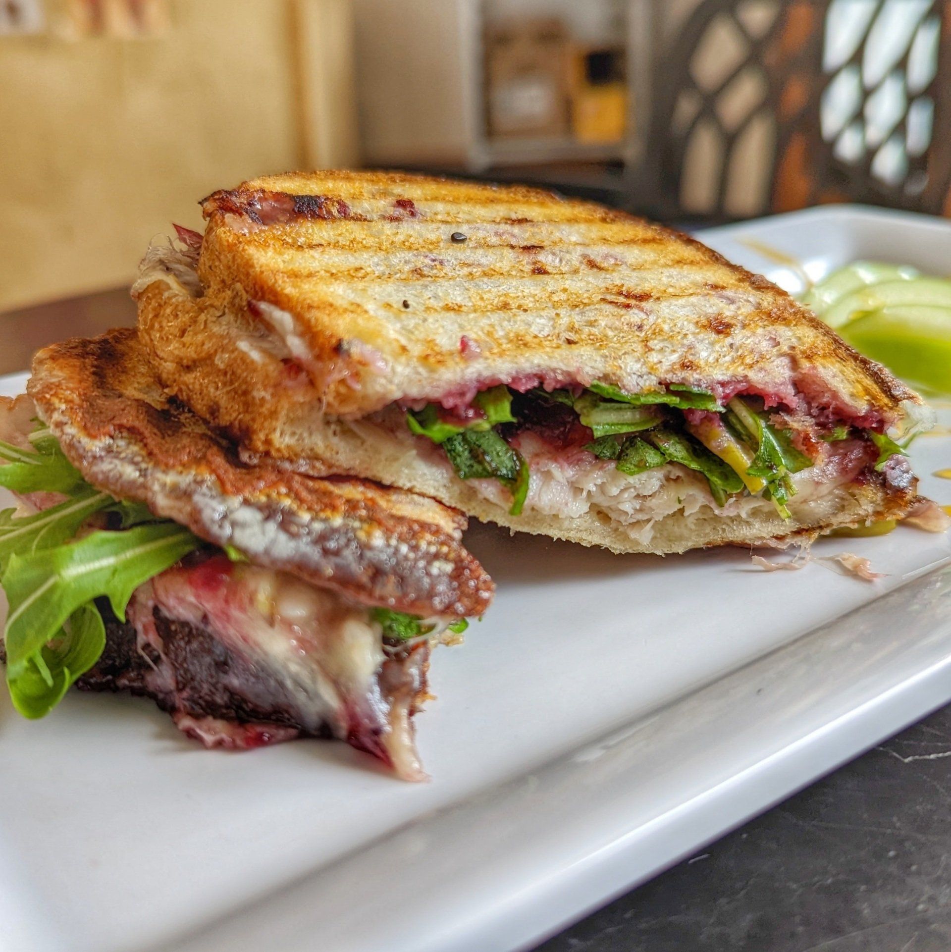 A close up of a sandwich on a white plate on a table.