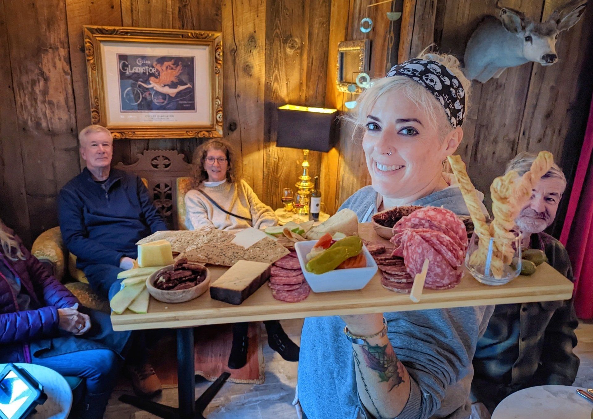A woman is holding a tray of food in front of a table.