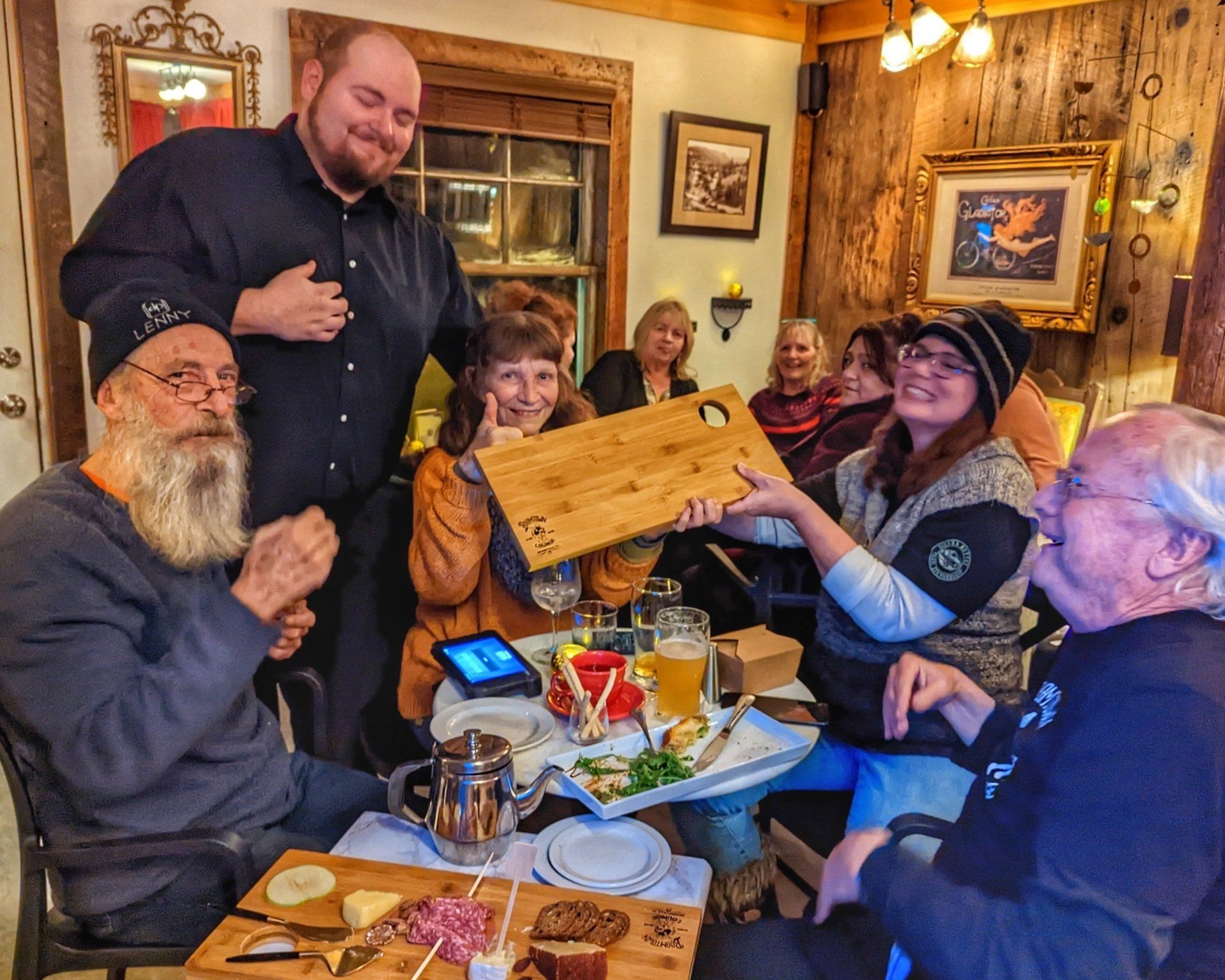 A group of people are sitting around a table eating and drinking
