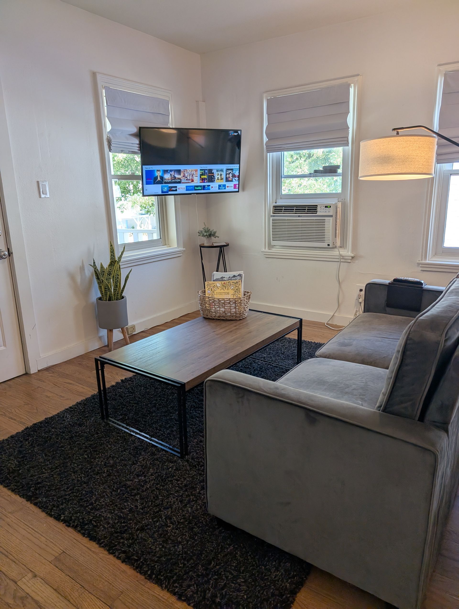 A living room with a couch , coffee table , and television.