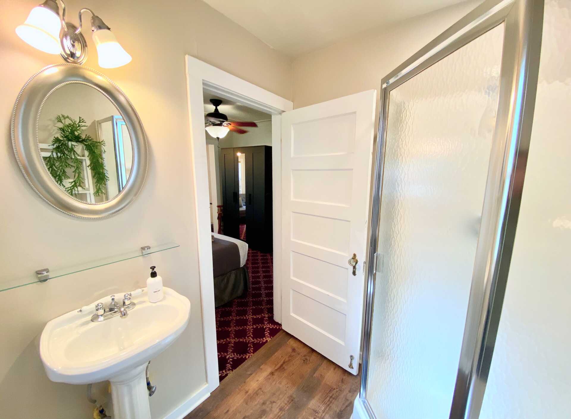 A bathroom with a sink , mirror , and shower.