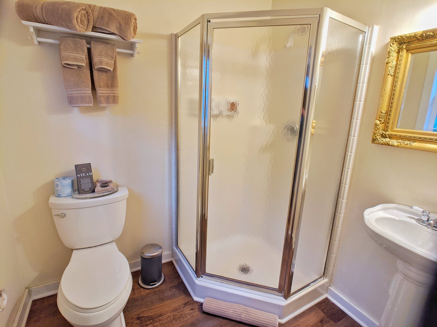 A bathroom with a toilet , sink and shower.