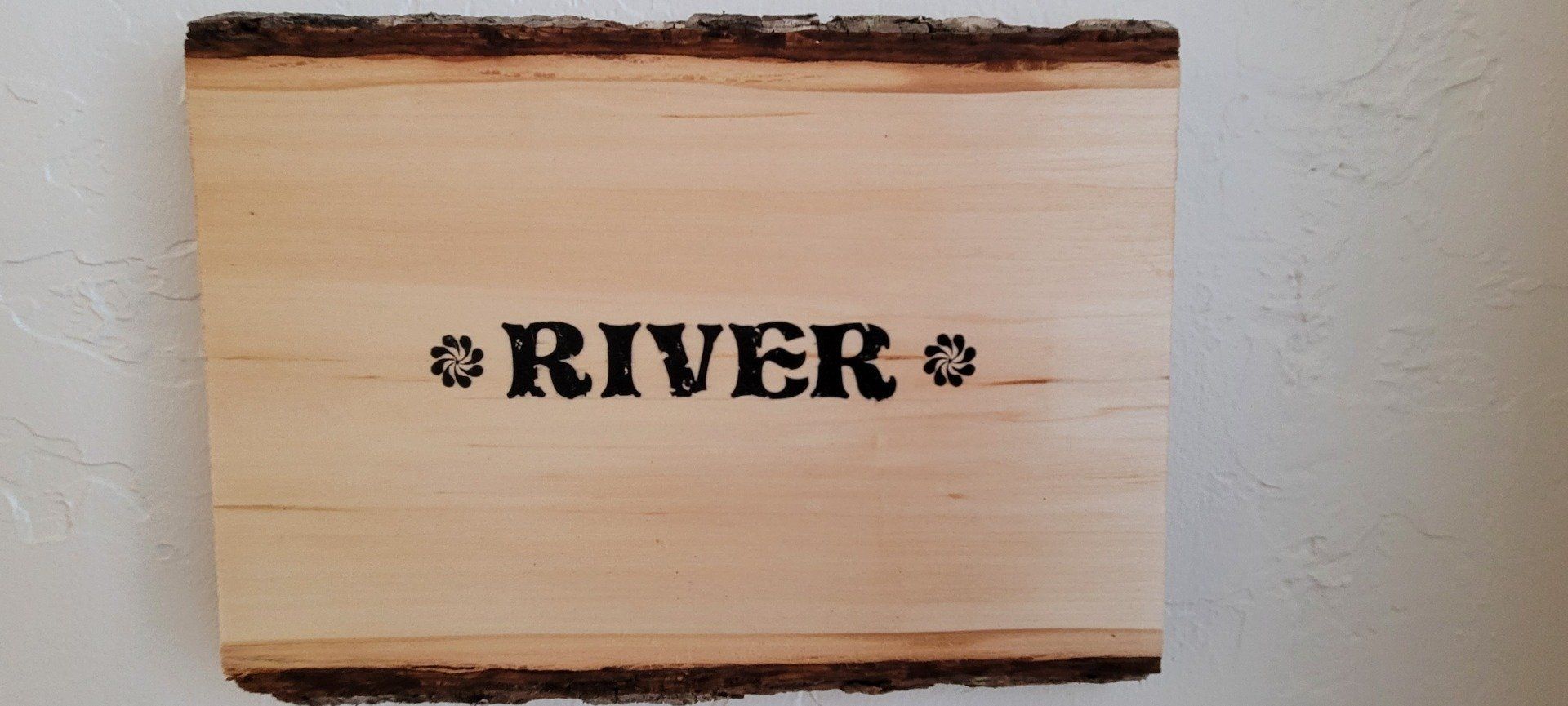 A piece of wood with the word river written on it