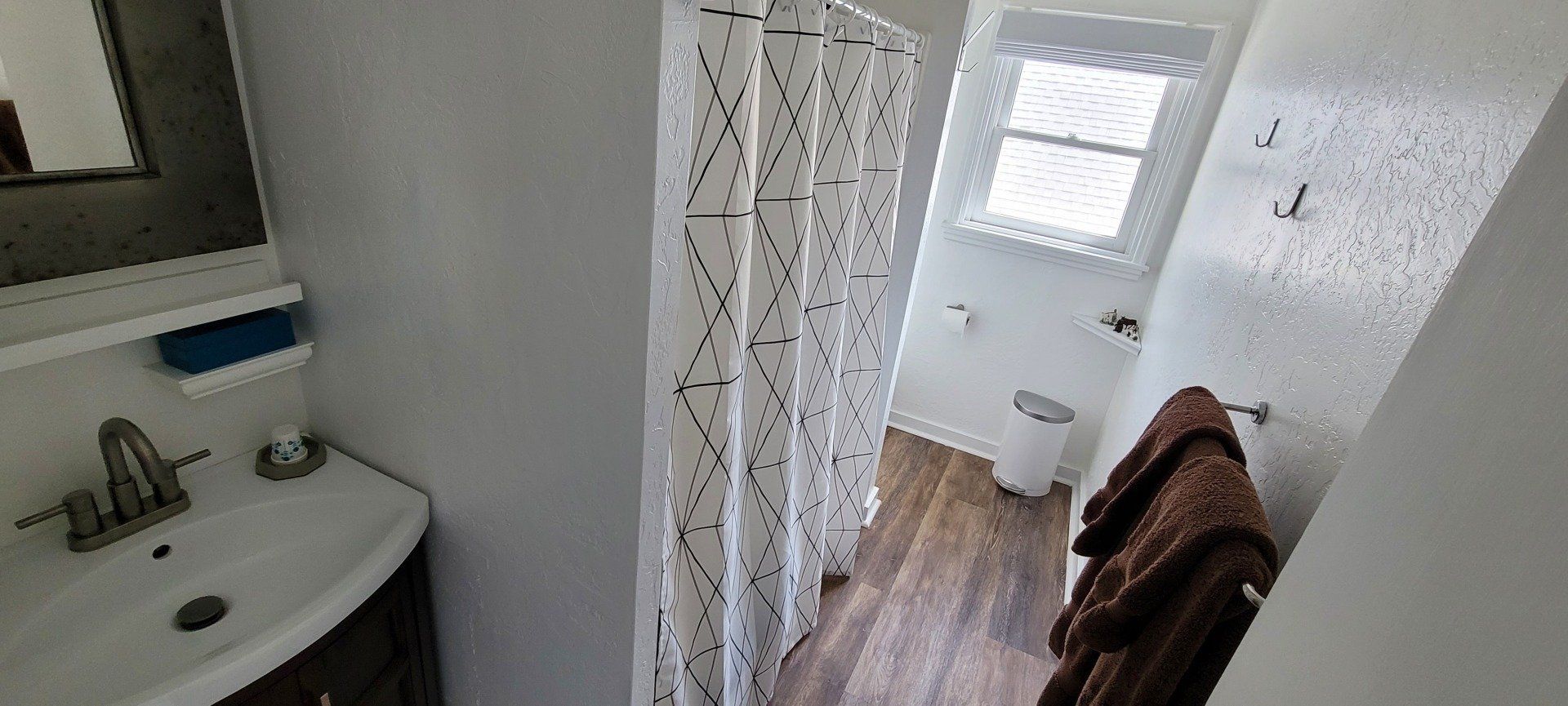 A bathroom with a sink , mirror and shower curtain.