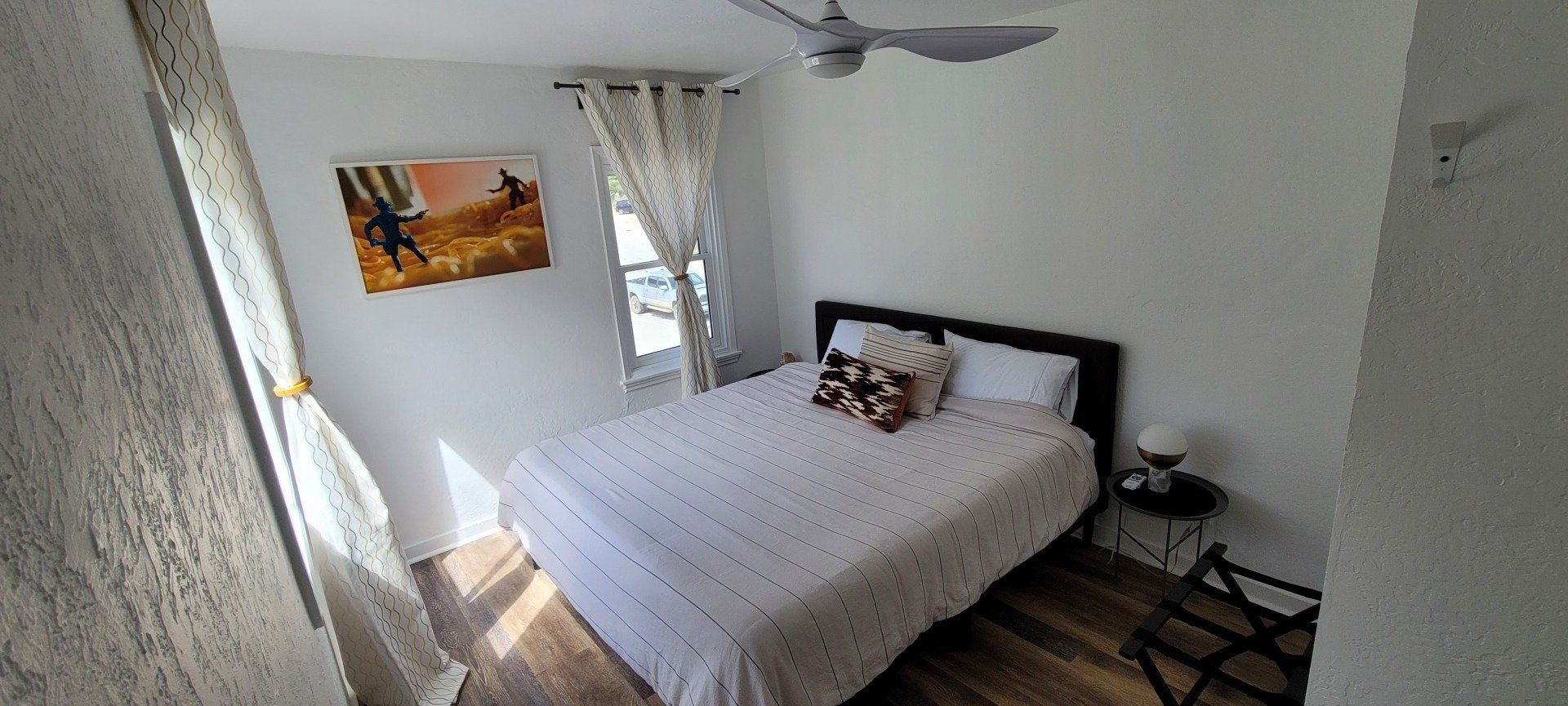 A bedroom with a bed and a ceiling fan.