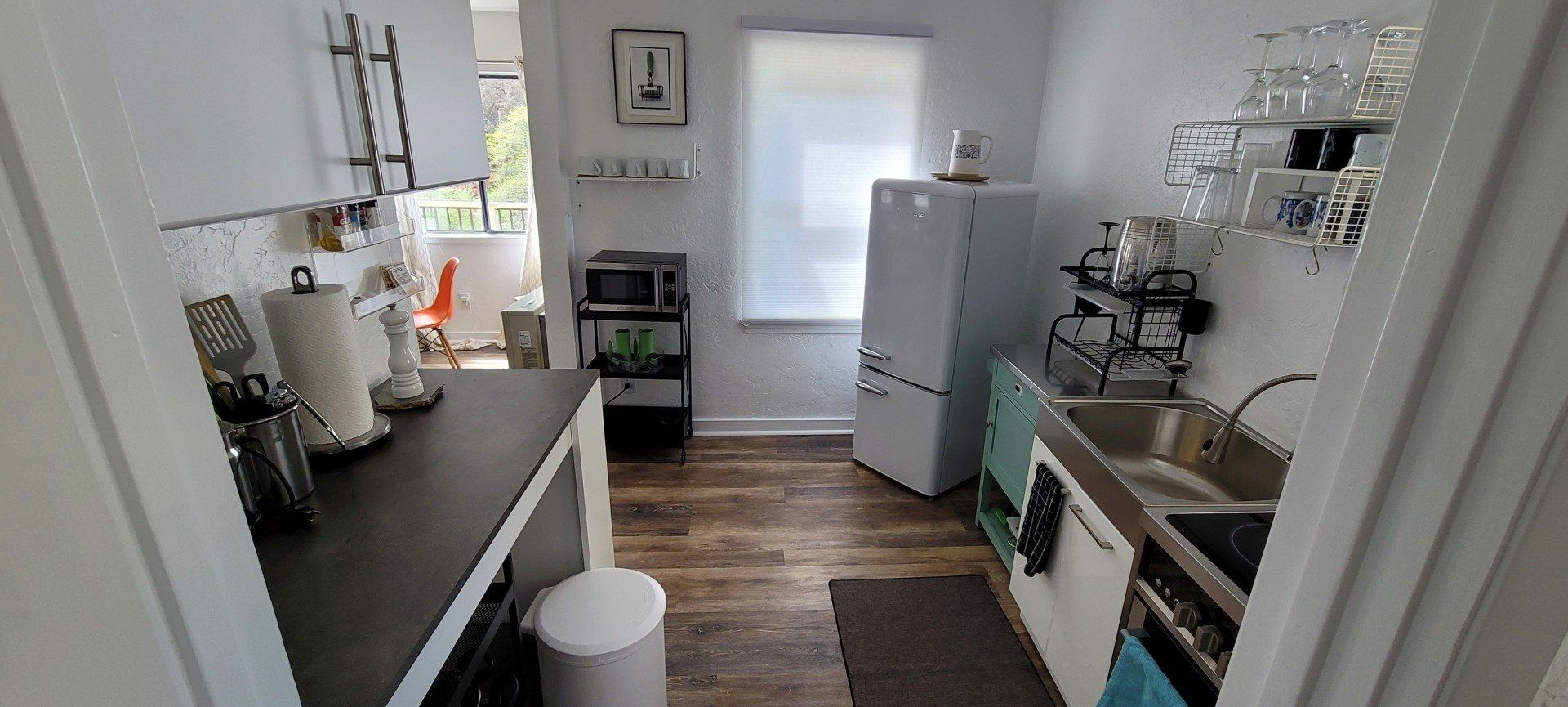 A kitchen with a sink , stove , refrigerator and microwave.