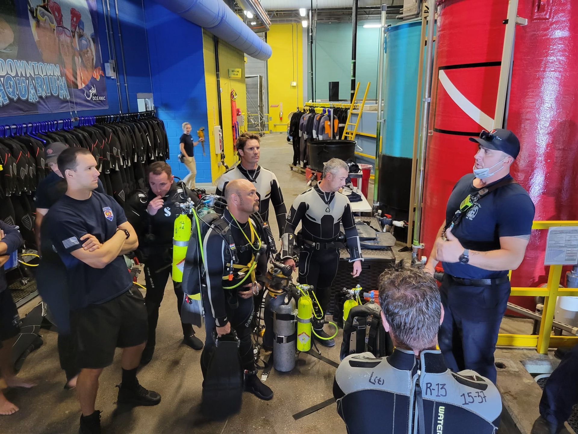 A group of scuba divers are gathered in a room