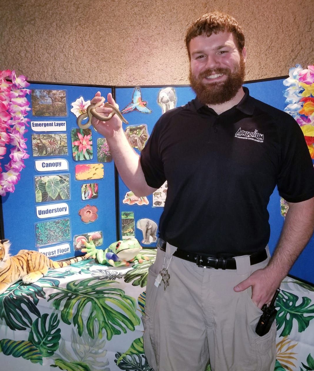 A man in a yellow shirt with a parrot painting a picture