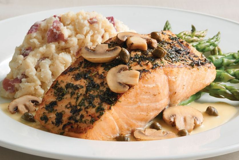 A white plate topped with salmon asparagus and risotto