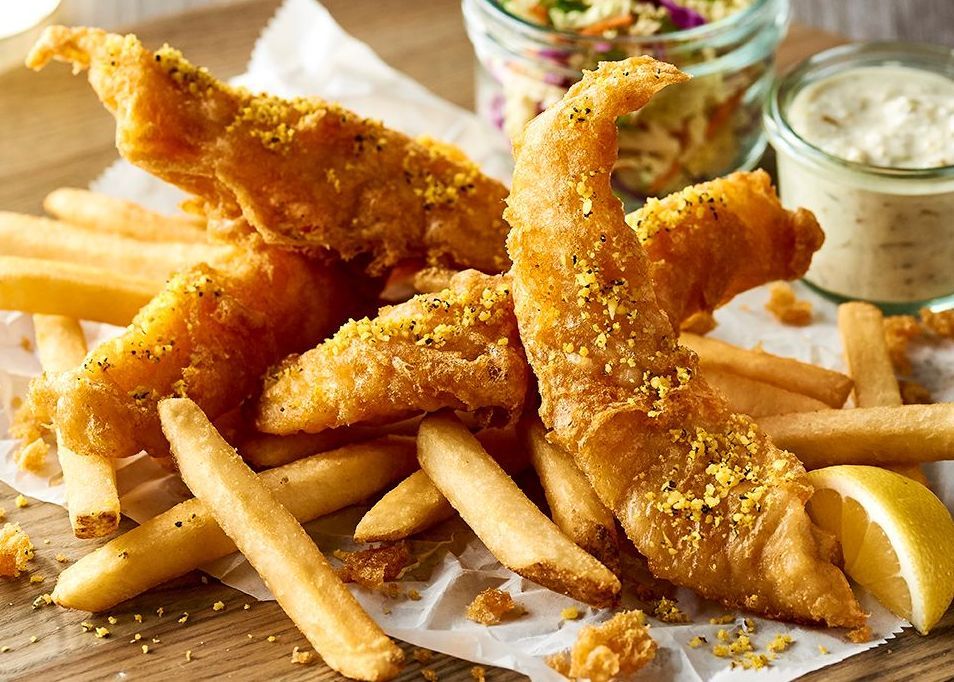 Fried fish and french fries on a wooden table