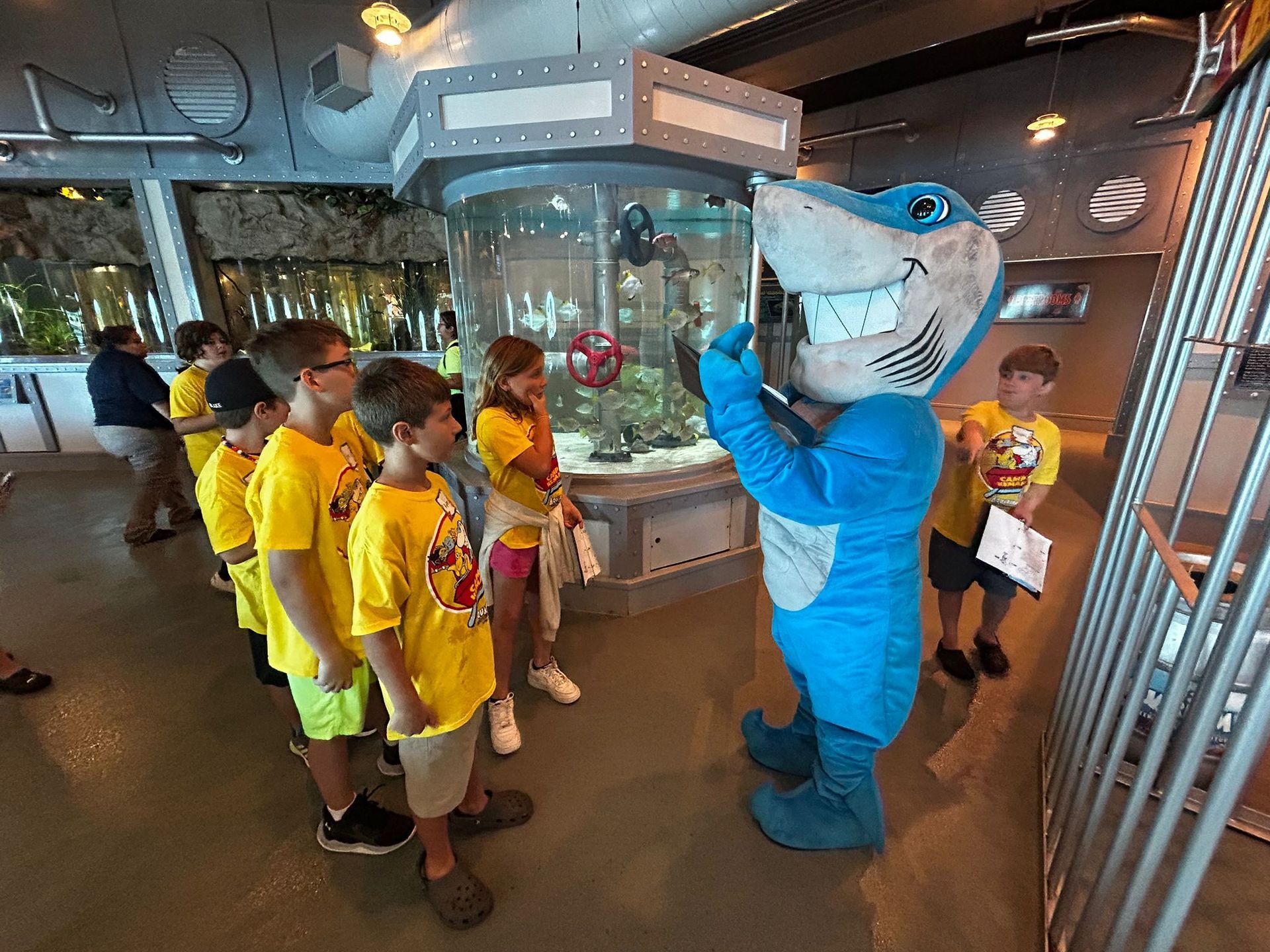 A group of children wearing red shirts looking at a parrot