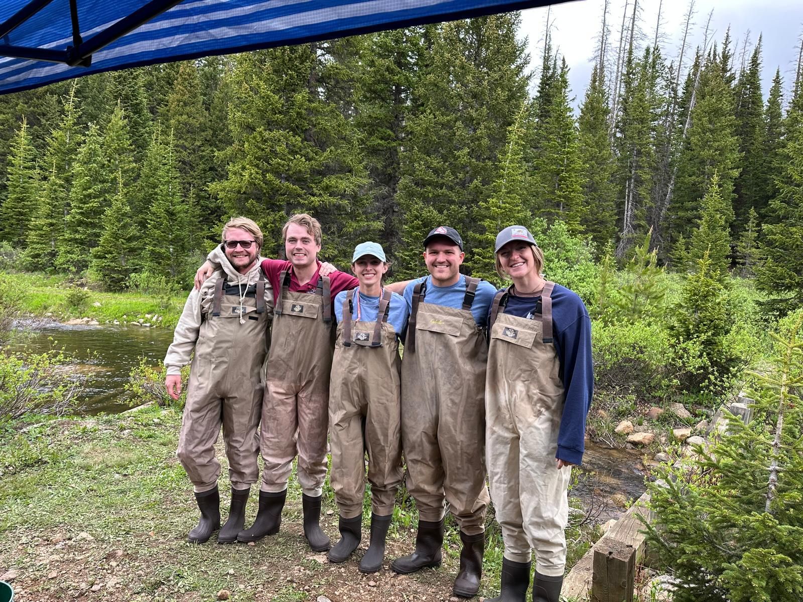 A group of men in waders are posing for a picture.