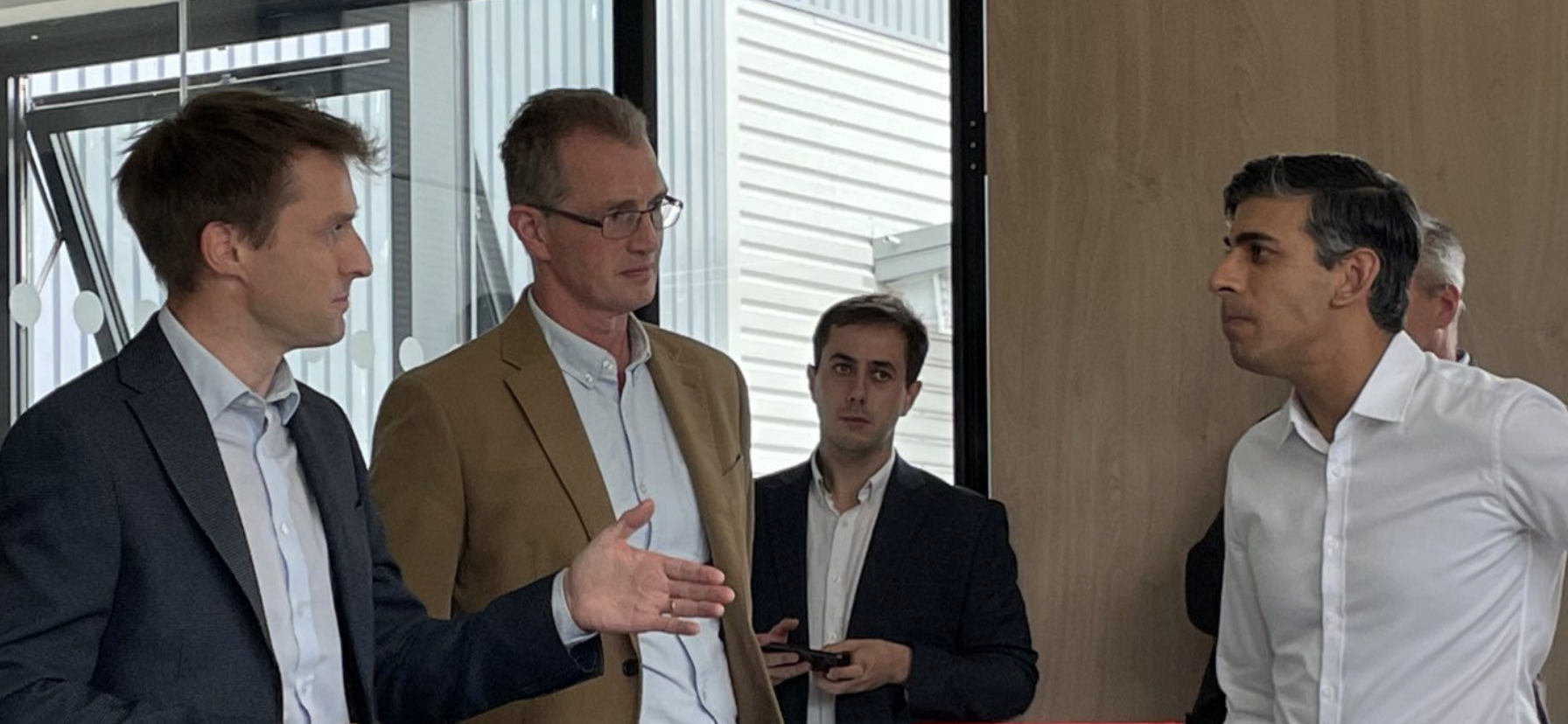 The Rt Hon David TC Davies speaking with the Prime Minister Rishi Sunak with a Special Advisor Tomos Povey in the background