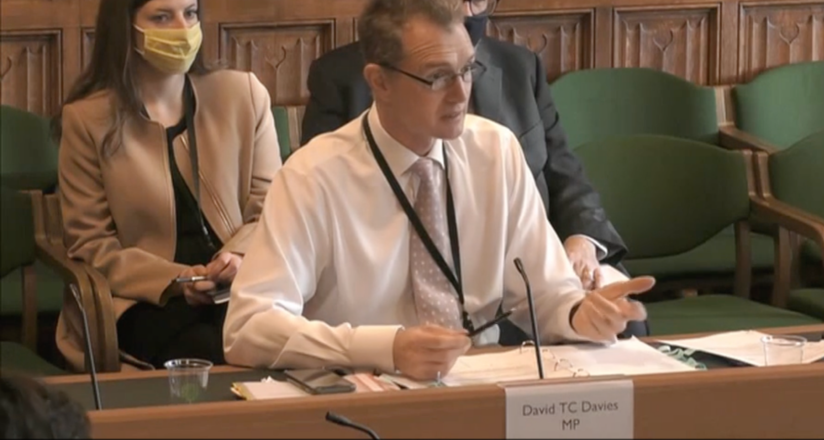 David Tc Davies - former Secretary of State for Wales sitting at a table talking into a microphone at a Commons Scrutiny Committee.