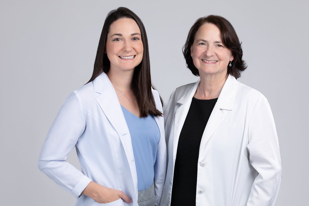 Deux femmes en blouse blanche posent pour une photo.