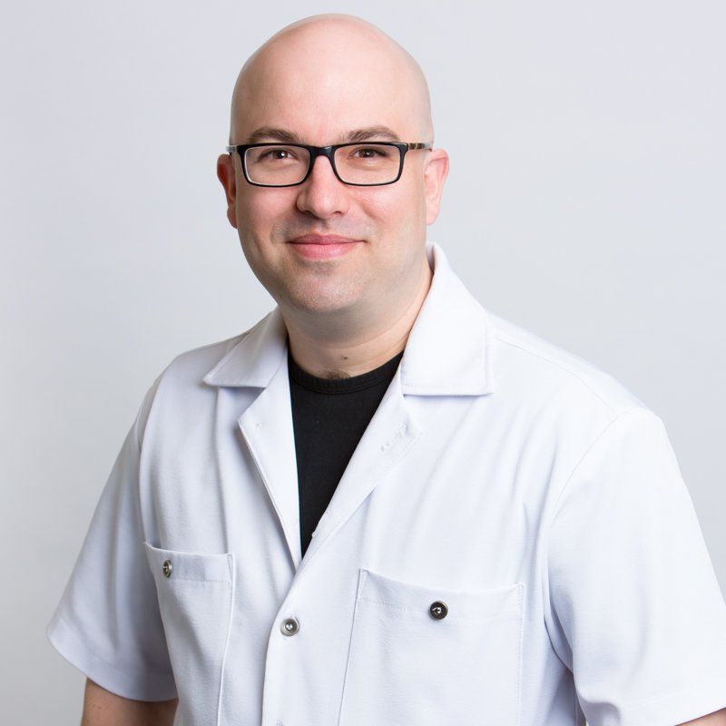 caucasian male dentist with white lab coat