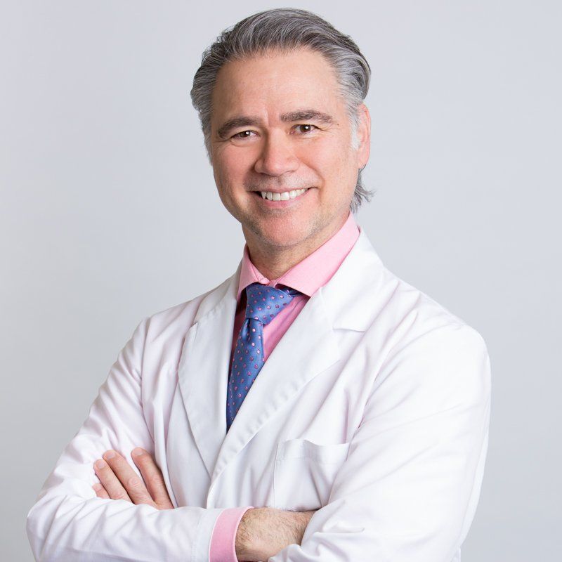 middle aged male dentist with pink dress shirt and with lab coat